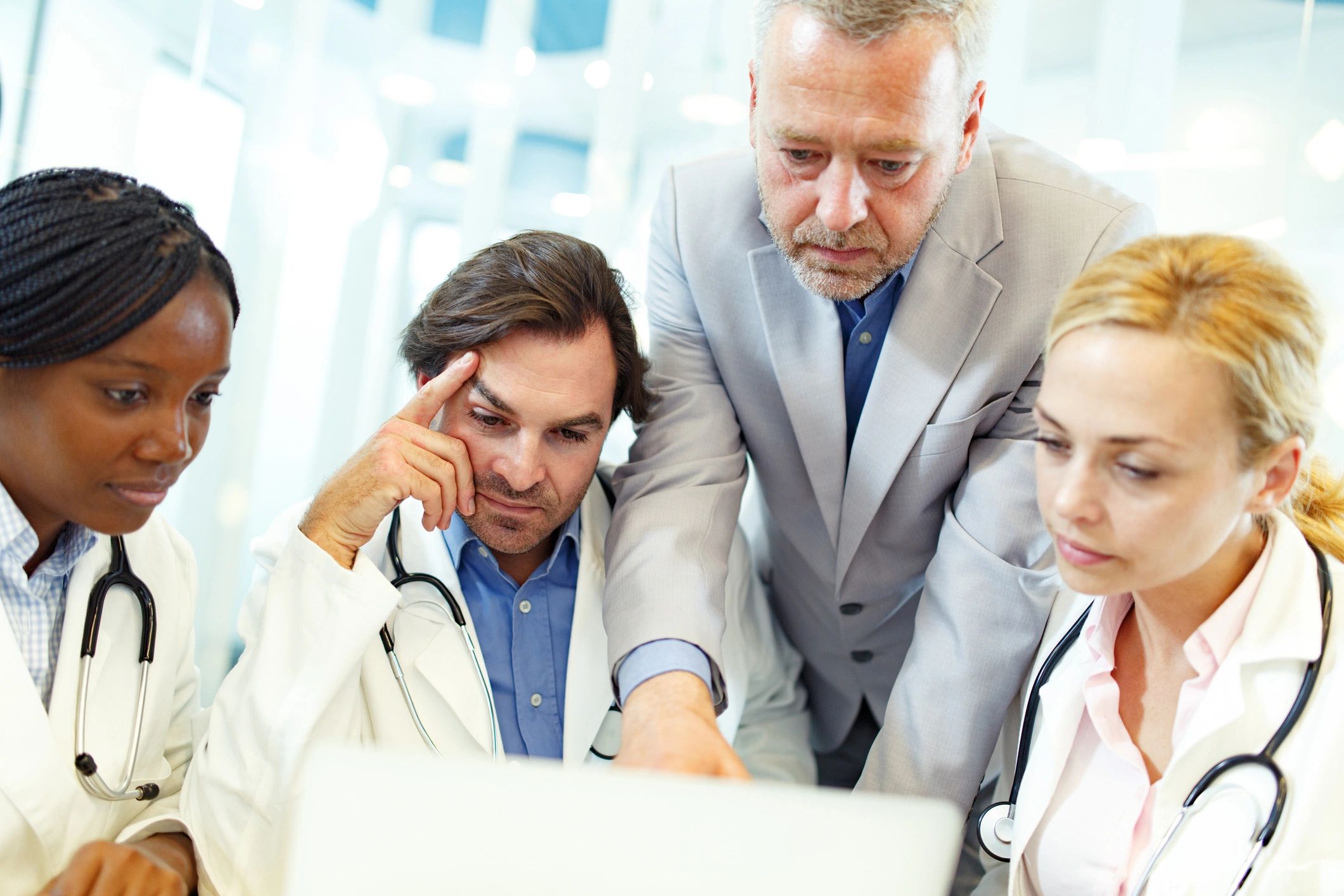 Medical team collaborating on a laptop in a doctor's office