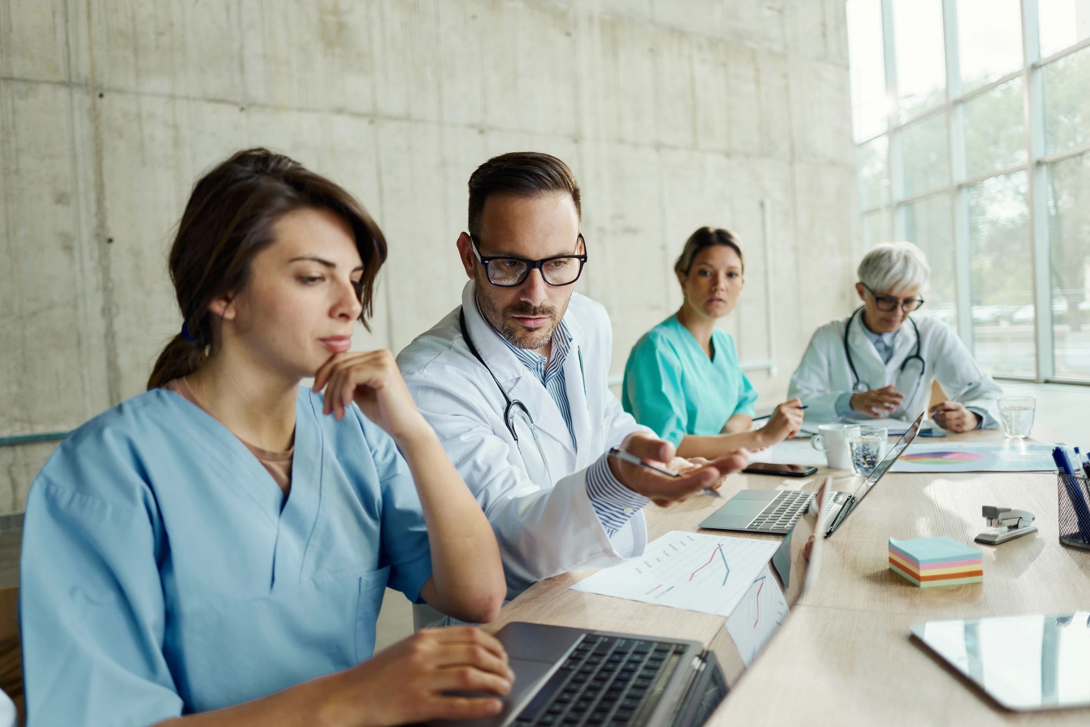 Medical team collaborating on a laptop in a clinic meeting