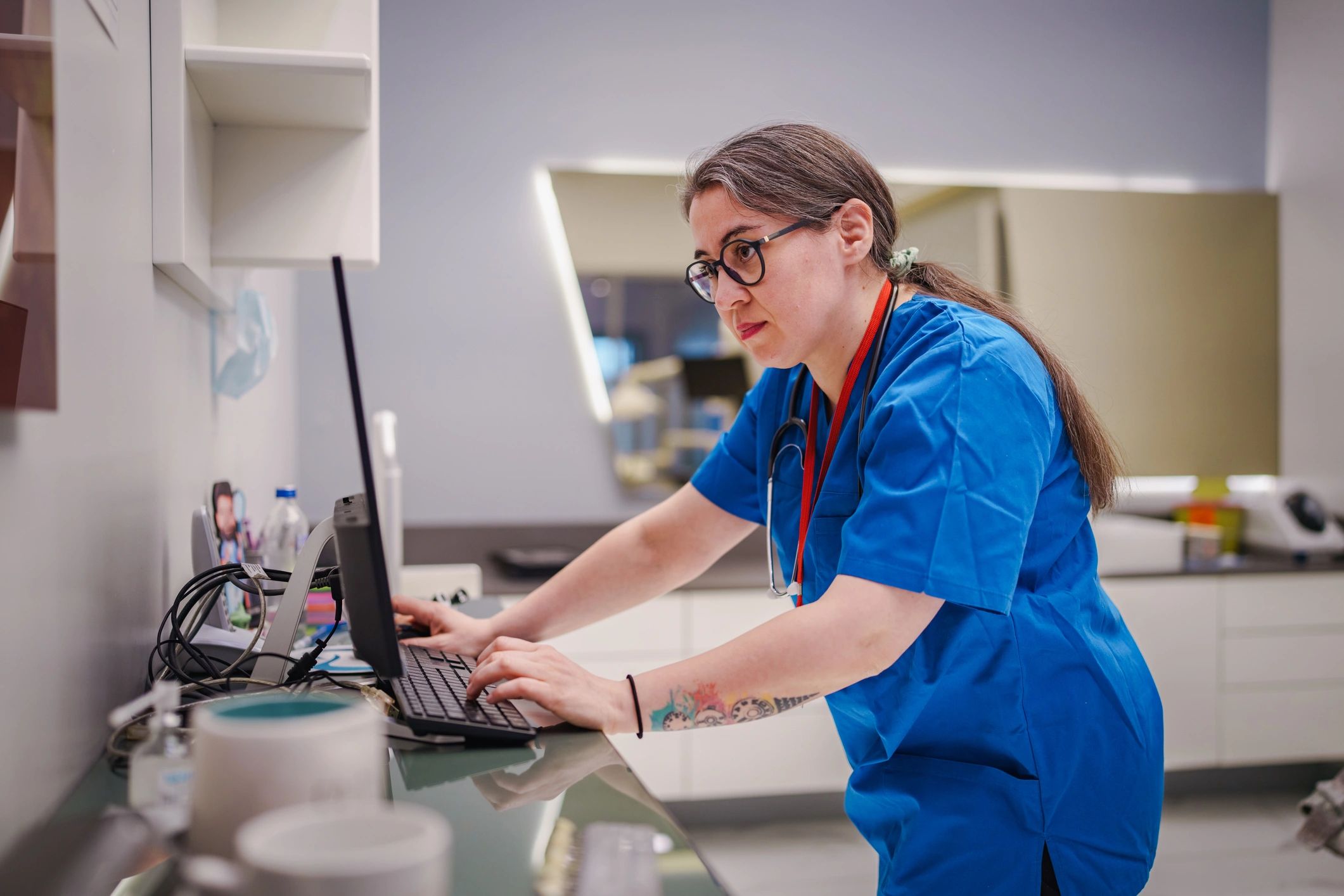 Healthcare professional managing appointments using a computer and phone